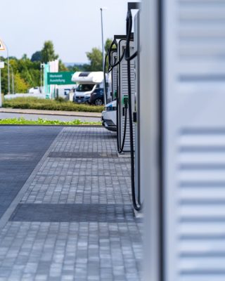 Outdoor view of an electric vehicle charging station with visible chargers and parking area.